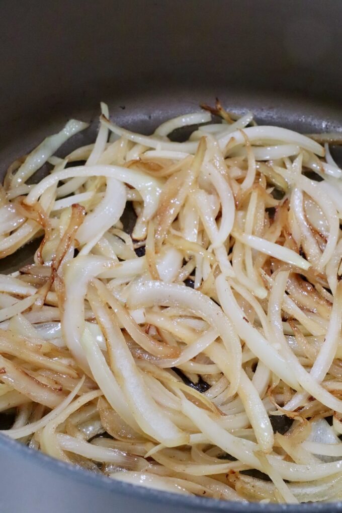 sliced onions cooking in a large pot