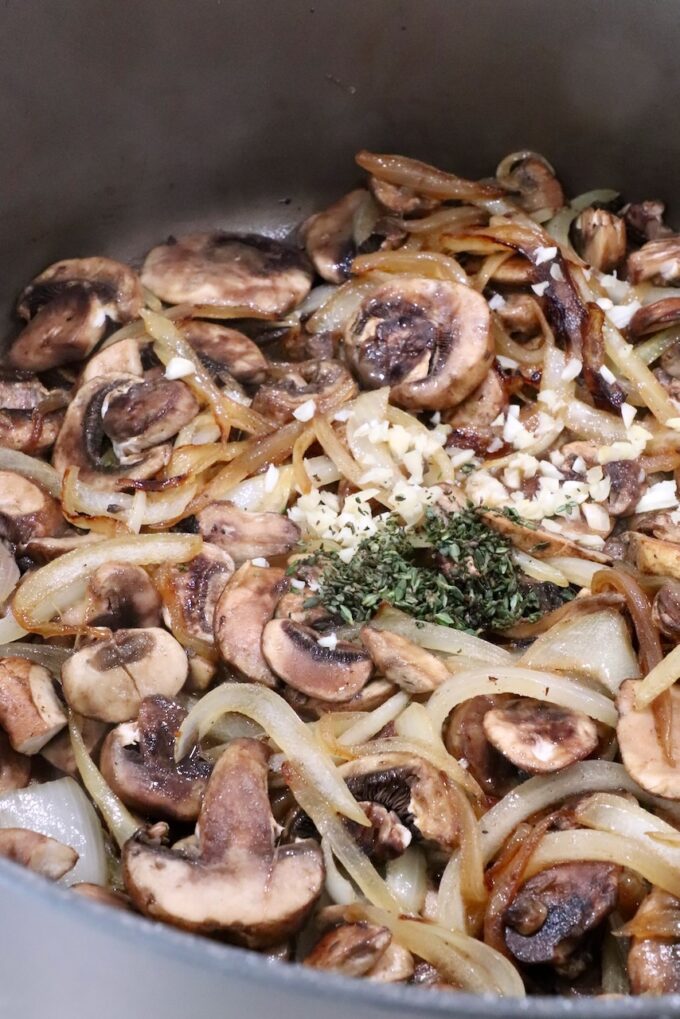 seasoned sliced onions and mushrooms in a pot