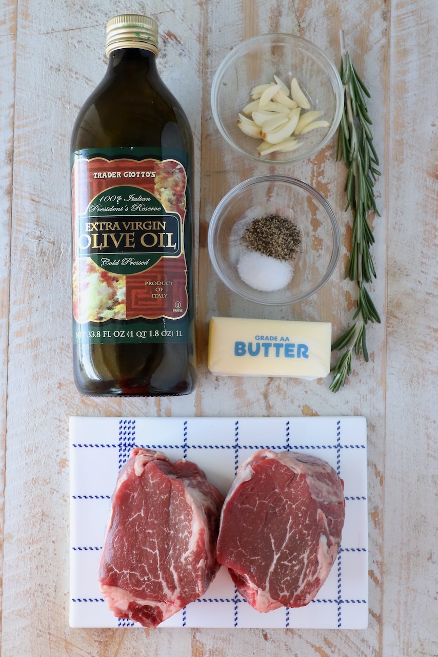 ingredients for filet mignon on a white wood board