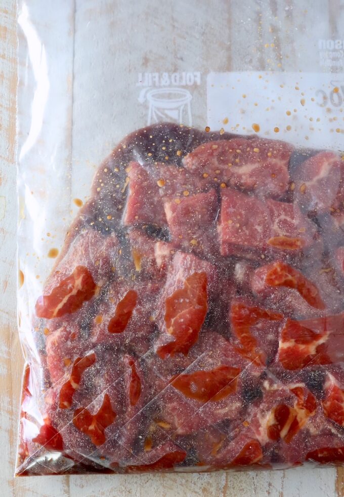 slices of beef in marinade in a plastic zipper bag