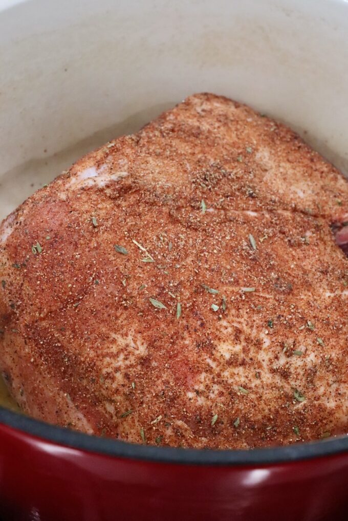 seasoned pork shoulder in a large cast iron pot