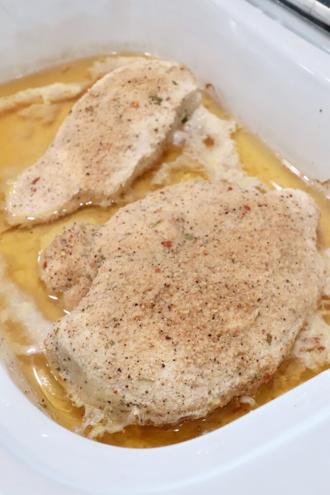 cooked seasoned chicken breasts in a slow cooker with chicken broth