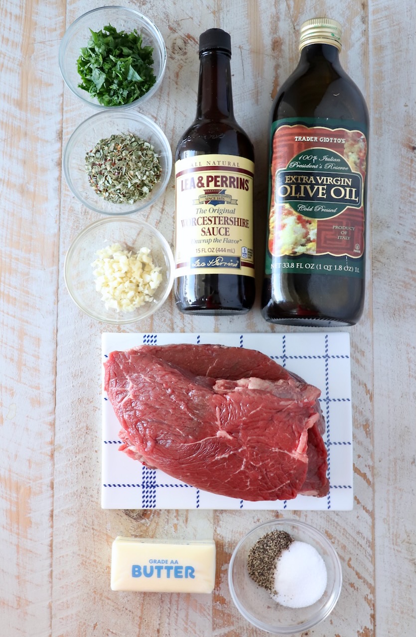 ingredients for garlic butter steak bites on a white wood board