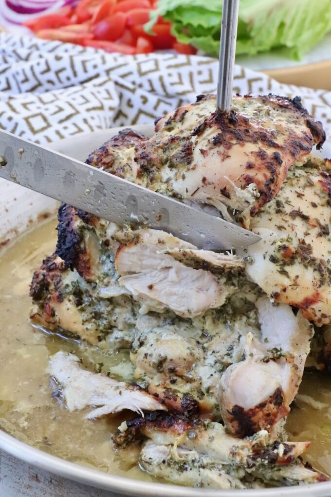 chicken sliced from a rotisserie with a large knife