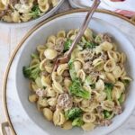 cooked orecchiette pasta with broccoli and Italian sausage in a bowl with a fork