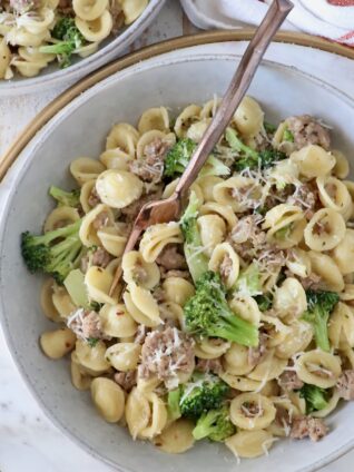 cooked orecchiette pasta with broccoli and Italian sausage in a bowl with a fork