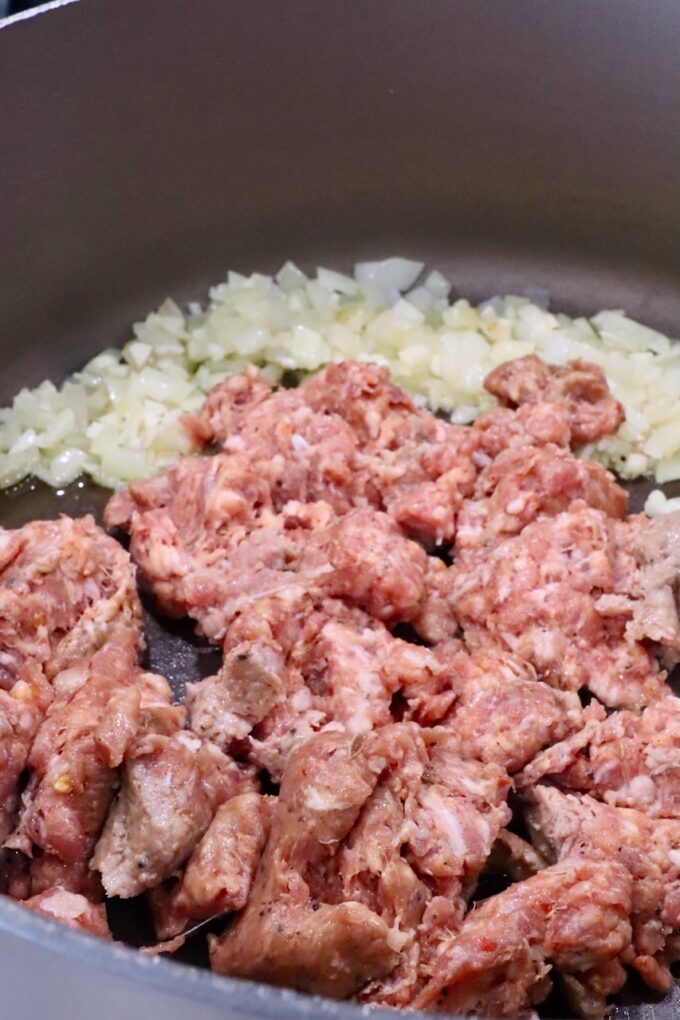 diced onion in a large pot with loose Italian sausage