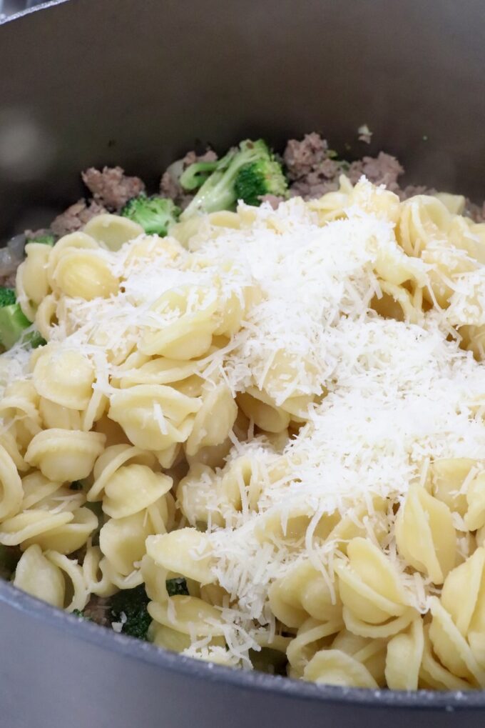 cooked pasta in a large pot topped with grated cheese