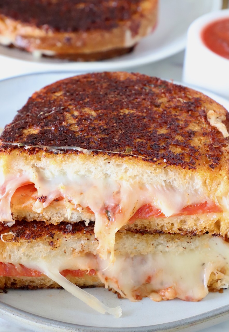 pizza grilled cheese cut in half and stacked up on a plate