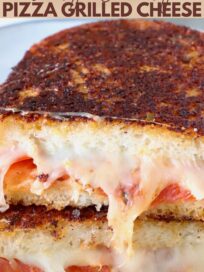 pizza grilled cheese sandwich cut in half on a plate