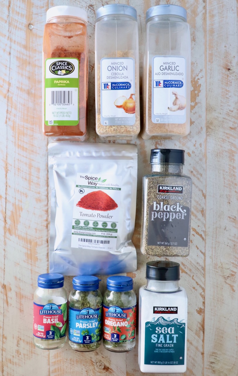 spices in plastic containers on a white wood board