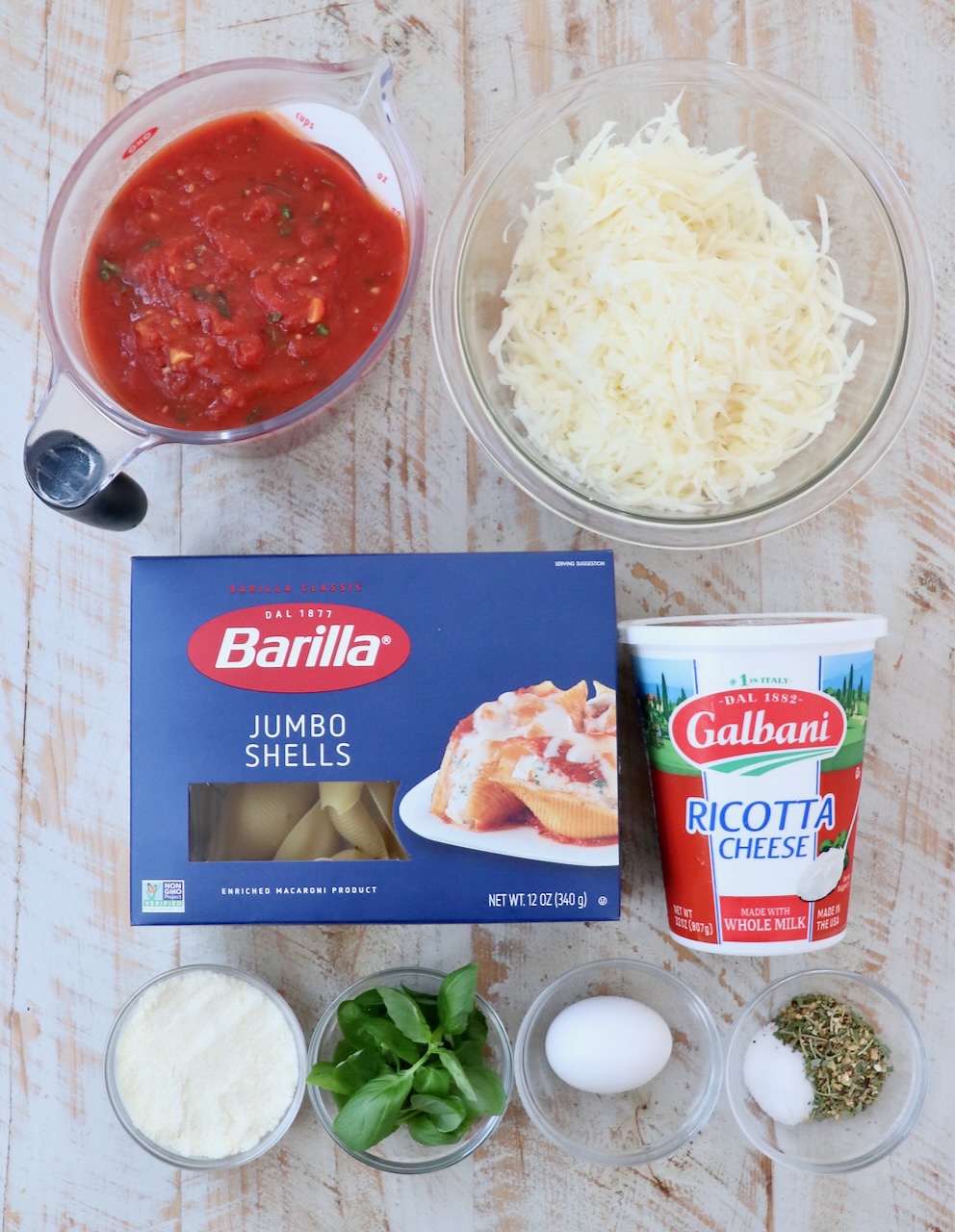 ingredients for stuffed shells on a white wood board