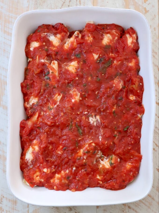 stuffed shells topped with marinara sauce in a casserole dish