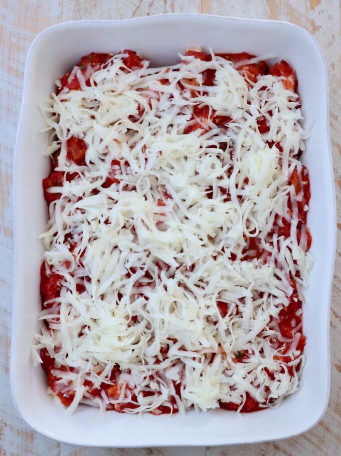 stuffed shells topped with marinara sauce and shredded mozzarella cheese in a casserole dish