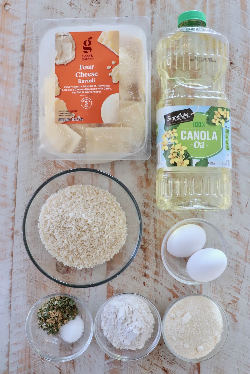 ingredients for toasted raviolis on a white wood board