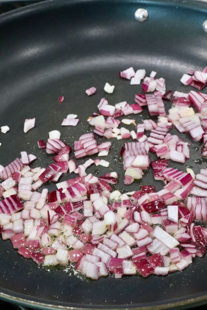 diced red onions in a skillet