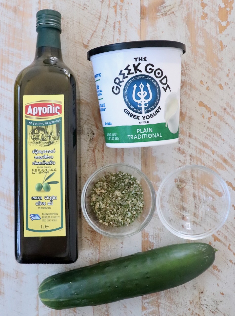 ingredients for tzatziki sauce on a white wood board