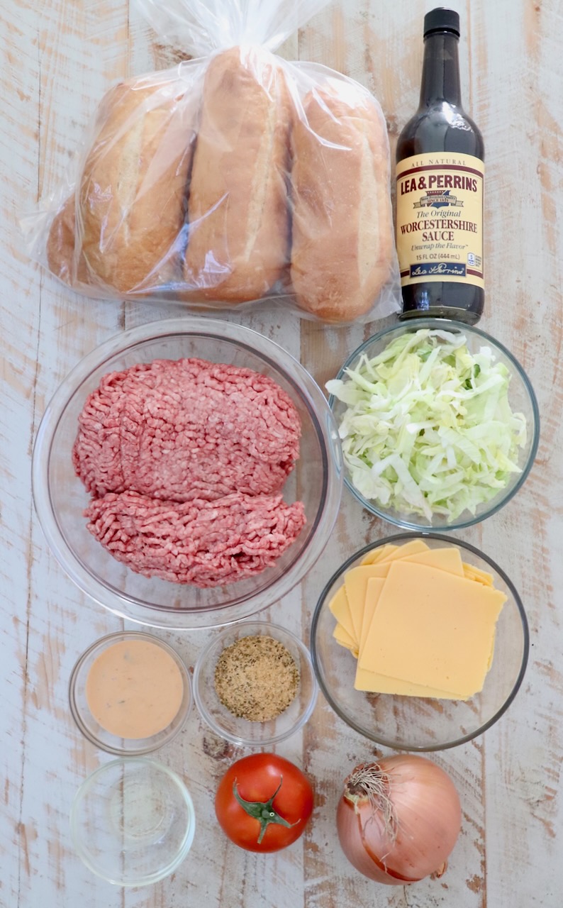 ingredients for chopped cheese sandwich on a white wood board