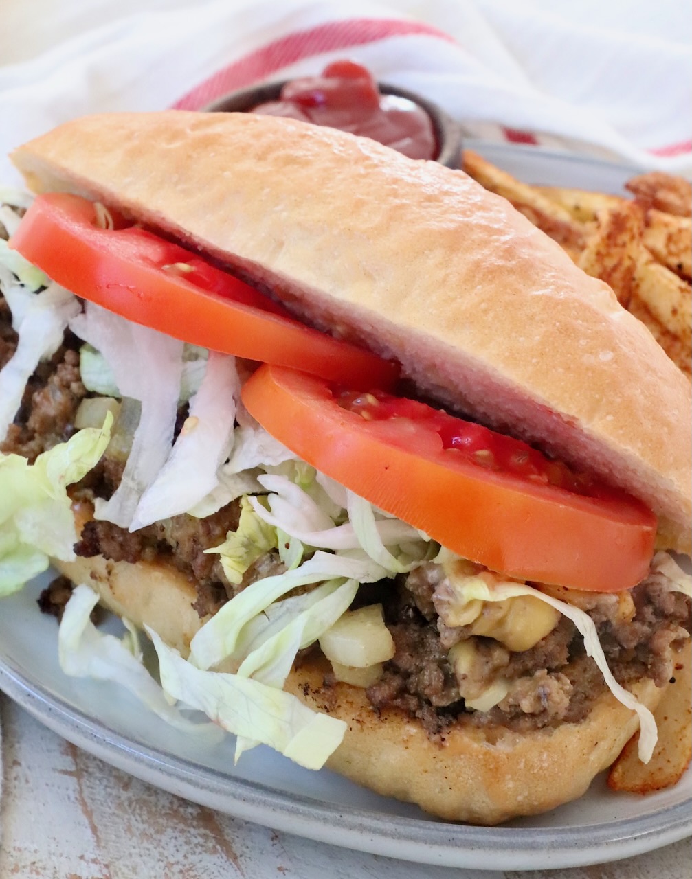 chopped cheese sandwich on a plate with fries