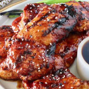 bbq glazed grilled chicken stacked up on a plate
