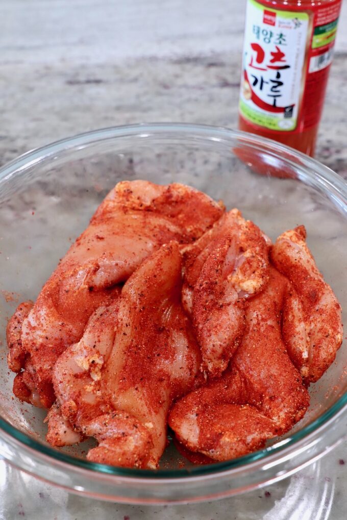 seasoned chicken thighs in a glass bowl