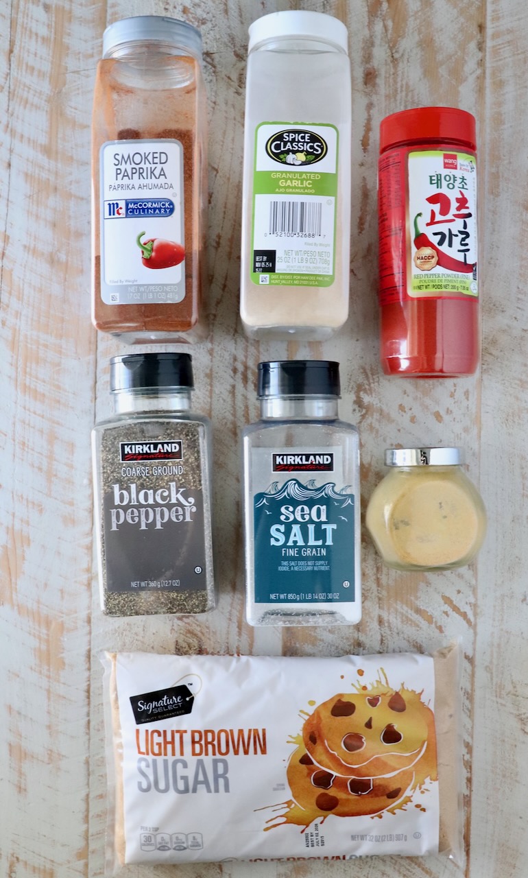 ingredients for Korean bbq seasoning in their containers sitting on a white wood board