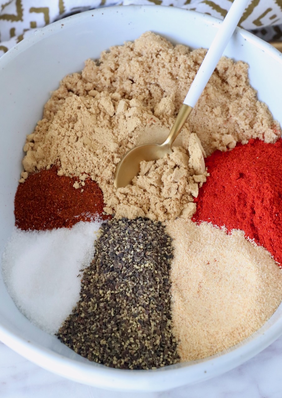 spices and brown sugar separated in a bowl with a spoon