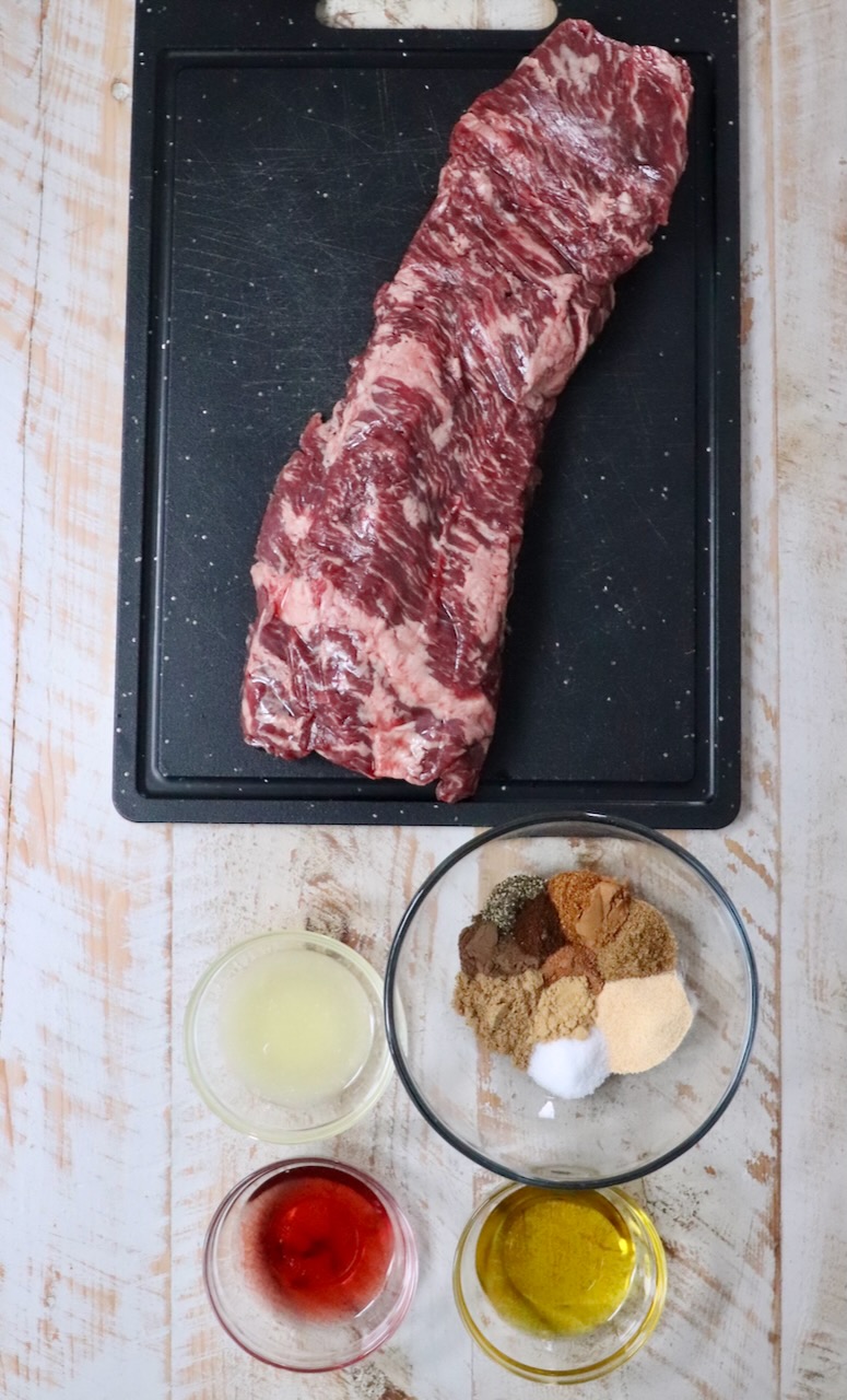 ingredients for beef shawarma on a white wood board