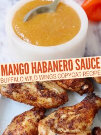 mango habanero sauce in a bowl with a spoon and cooked chicken wings on a plate
