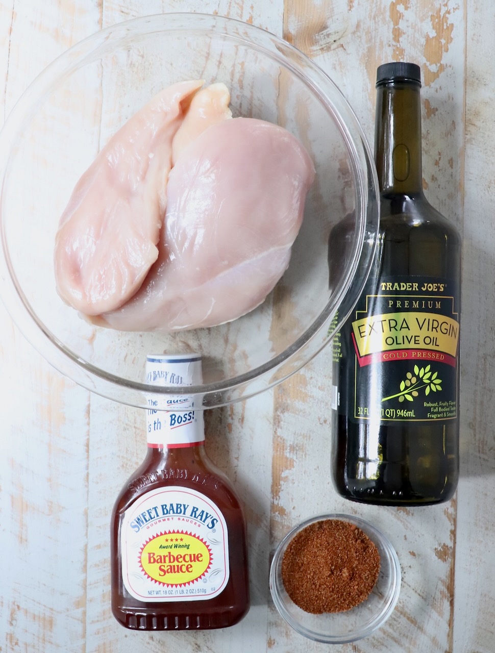 ingredients for smoked chicken breasts on a white wood board