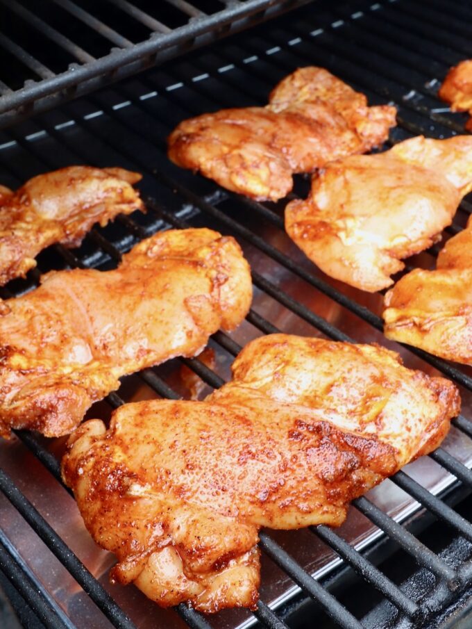 seasoned chicken thighs on a smoker
