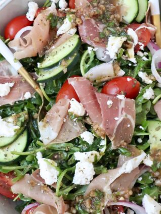 salad in a bowl with prosciutto, cucumber, tomatoes and feta cheese