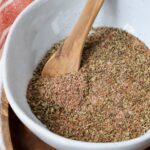 carnitas seasoning in a bowl with a wooden spoon