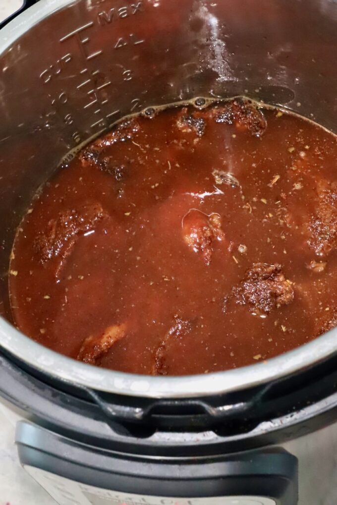 beef covered in liquid in an Instant Pot