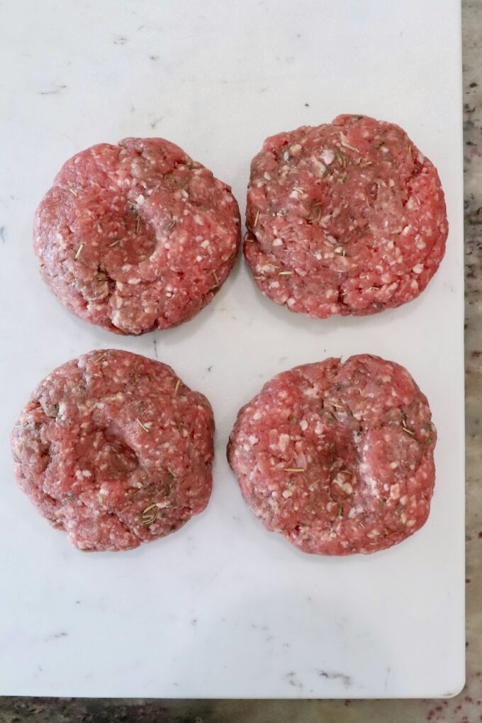 lamb burger patties on a white cutting board