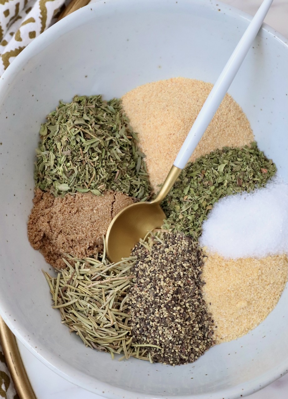 dried herbs and spices separated in a bowl with a spoon