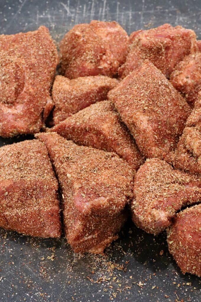 seasoned chunks of pork on a cutting board