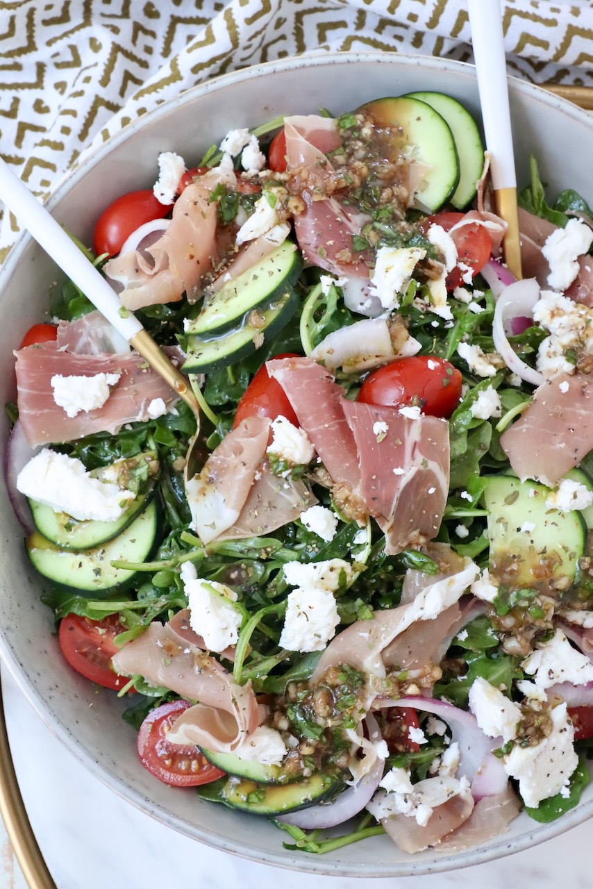 salad in a bowl with prosciutto, cucumber, tomatoes and feta cheese
