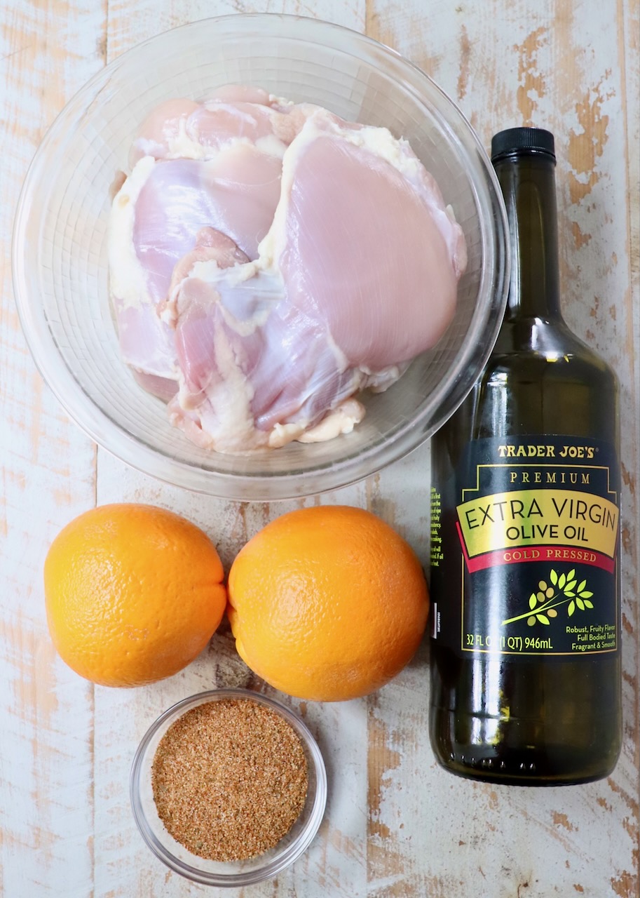 ingredients for sazon chicken on a white wood board