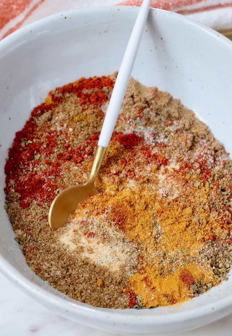 spices mixed together in a bowl with a small spoon