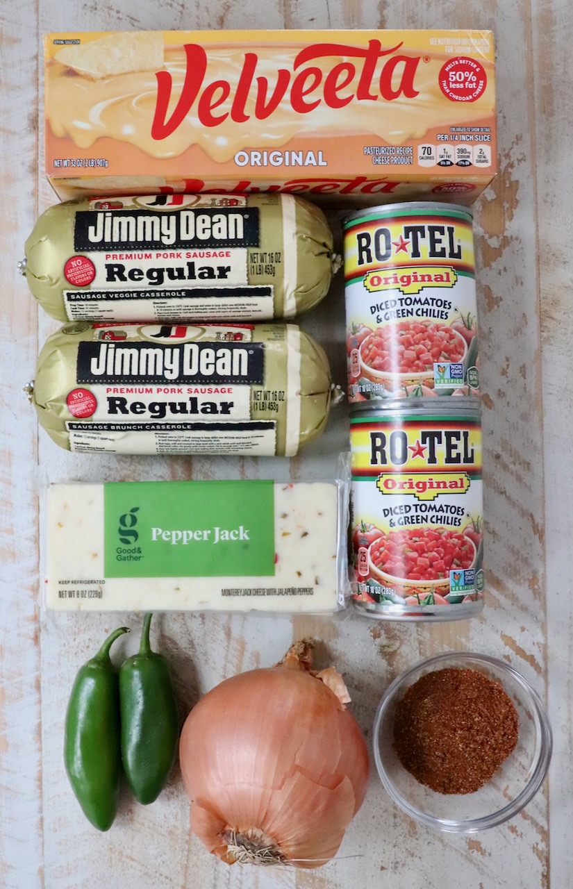 ingredients for smoked queso on a white wood board