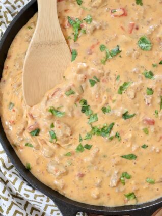 smoked queso dip in a skillet with a wooden spoon