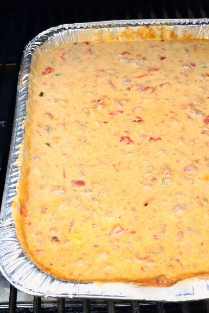 queso dip in an aluminum pan on a smoker