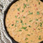 smoked queso dip in a skillet topped with fresh cilantro