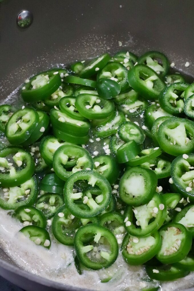 sliced jalapenos in a pot of boiling liquid