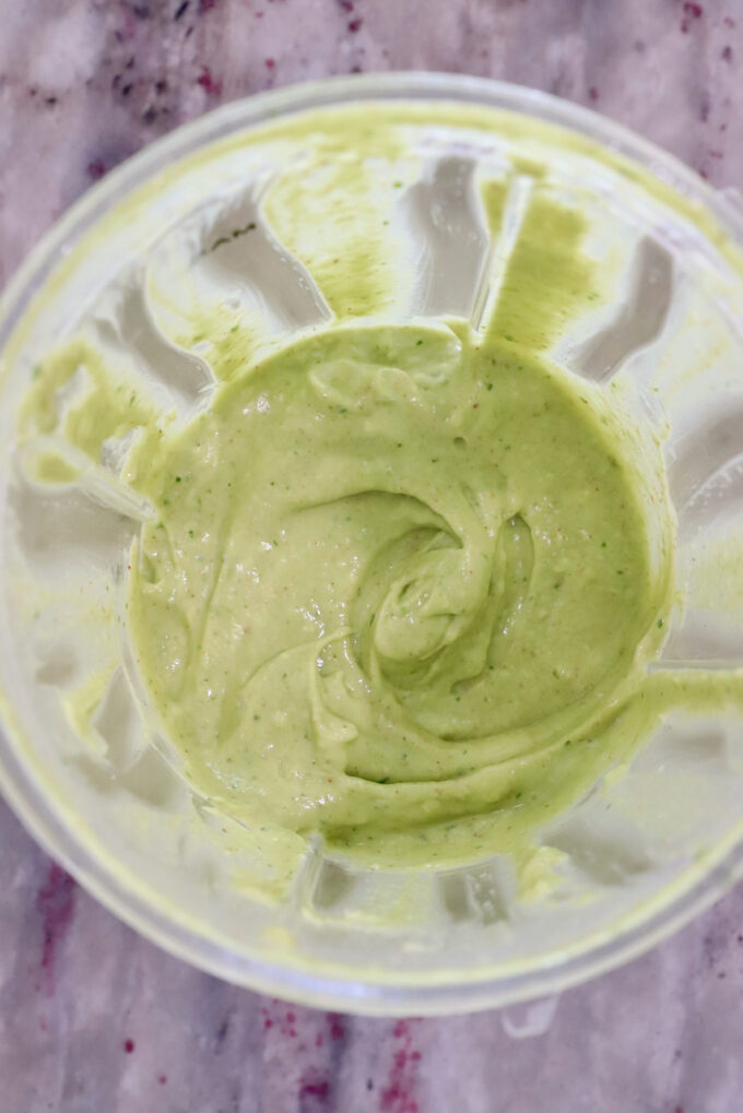 creamy avocado dressing in a plastic blender cup