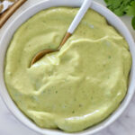 creamy avocado dressing in a bowl with a spoon