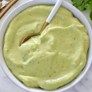 creamy avocado dressing in a bowl with a spoon