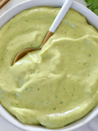 creamy avocado dressing in a bowl with a spoon