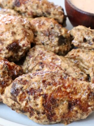 cooked chicken wings tossed in a creamy sauce on a plate